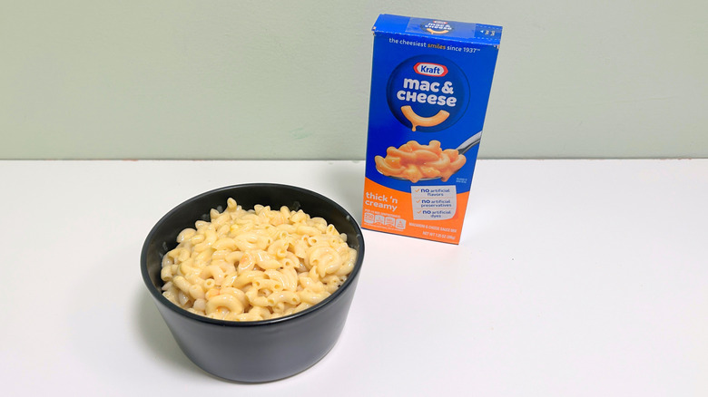A  box of Kraft Thick 'n Creamy Mac and Cheese next to a  bowl of mac and cheese