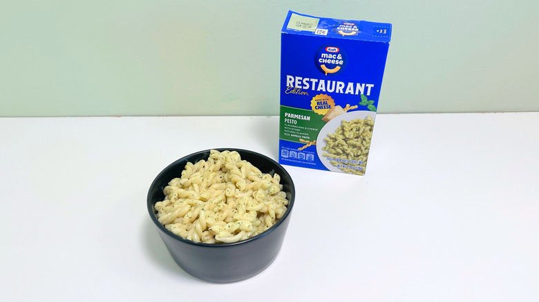 A box of Kraft Restaurant Edition Parmesan Pesto Mac and Cheese next to a bowl of mac and cheese
