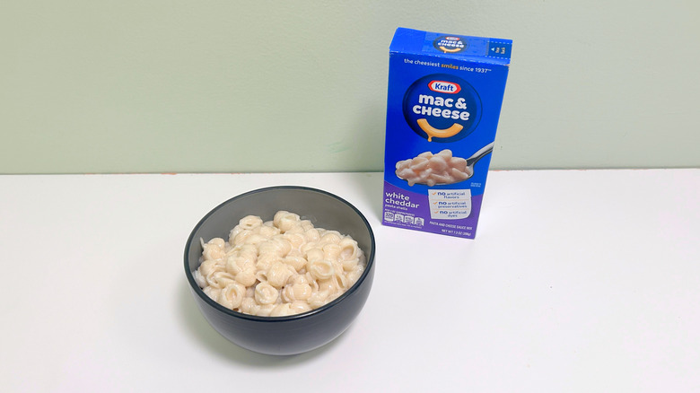 A box of Kraft White Cheddar Mac and Cheese next to a bowl of mac and cheese