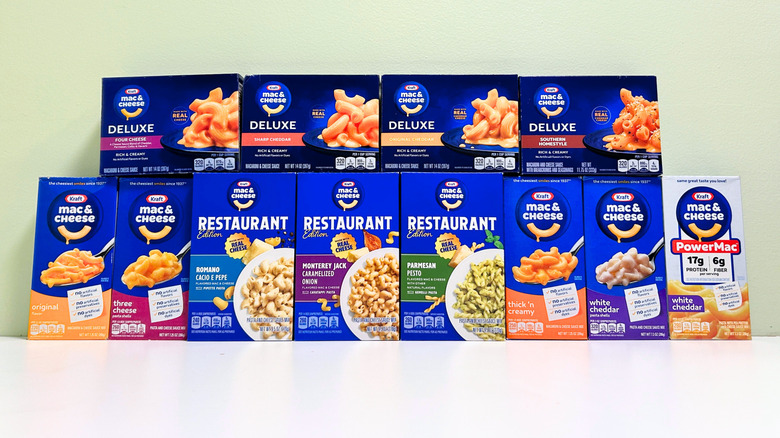 Twelve boxes of Kraft Mac and Cheese flavors arranged in two vertical rows