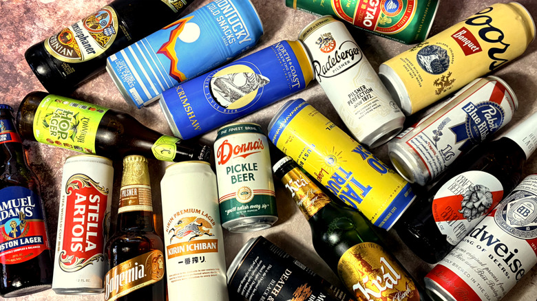 Various cans and bottles of lagers arranged on table