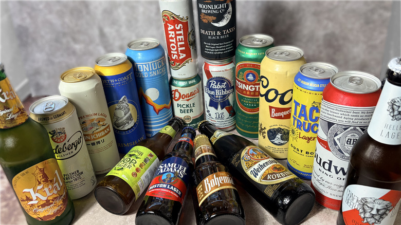 Various cans and bottles of lagers arranged on table