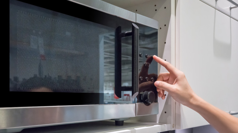 person pressing button on control panel