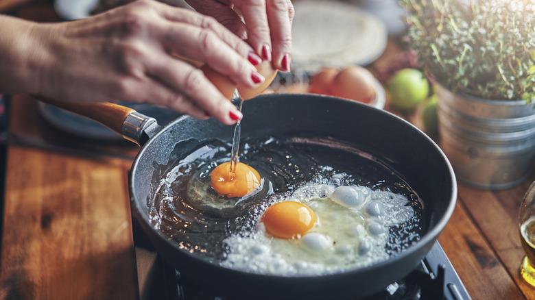 Cracking eggs into nonstick pan