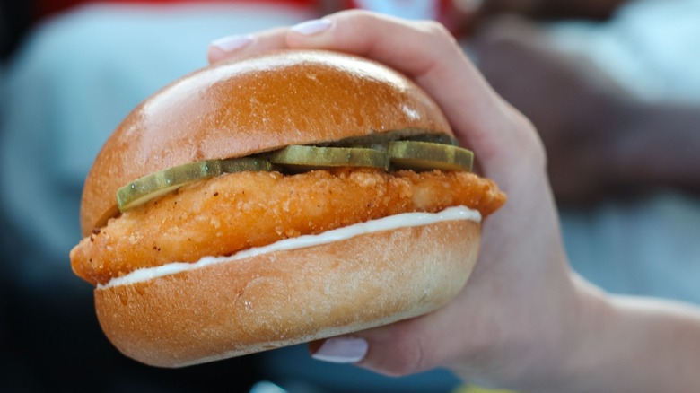hand holding crispy chicken sandwich