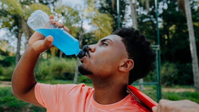 man drinking blue sports drink
