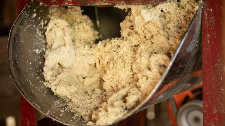 Corn masa being ground in a traditional machine
