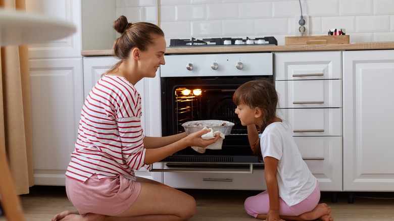 mother and daughter using oven