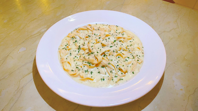 A bowl of creamy Fettuccine Alfredo garnished with parsley