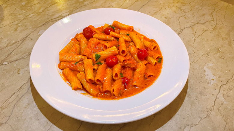 A bowl of spicy rigatoni with vodka sauce on a table top