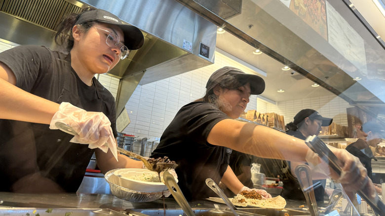 Workers fulfill orders at a Chipotle restaurant