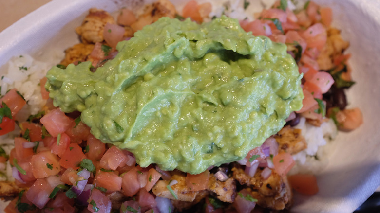 A bowl of food from Chipotle, with guacamole on top
