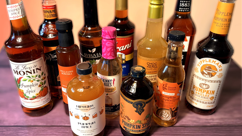 Various bottles of pumpkin spice syrup arranged on table