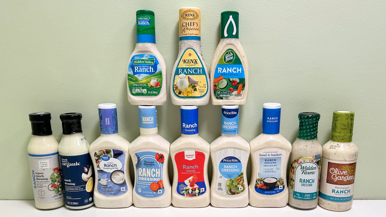 Twelve bottles of ranch dressing from different brands arranged in two rows