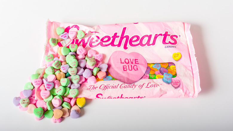 Bag of Sweethearts candy with hearts spilling out of the bag.