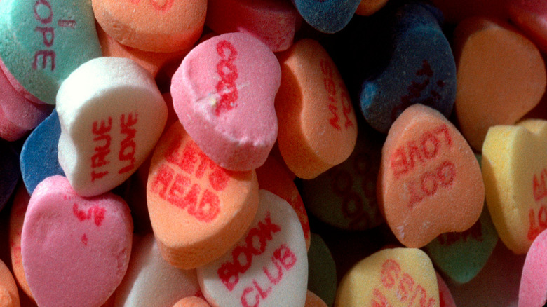 Candy hearts with words stamped on them in red lettering.