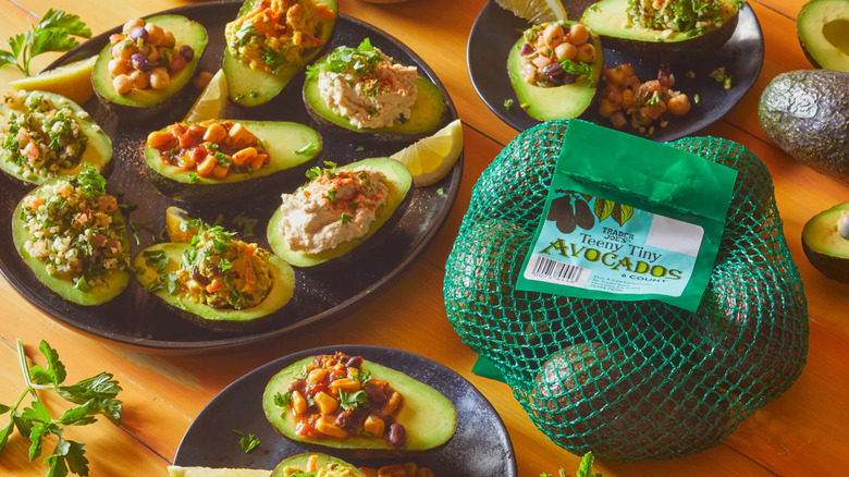 Avocados stuffed with various fillings and a bag of teeny tiny avocados