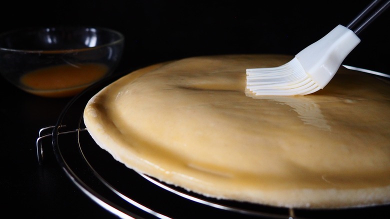 painting egg wash onto pie