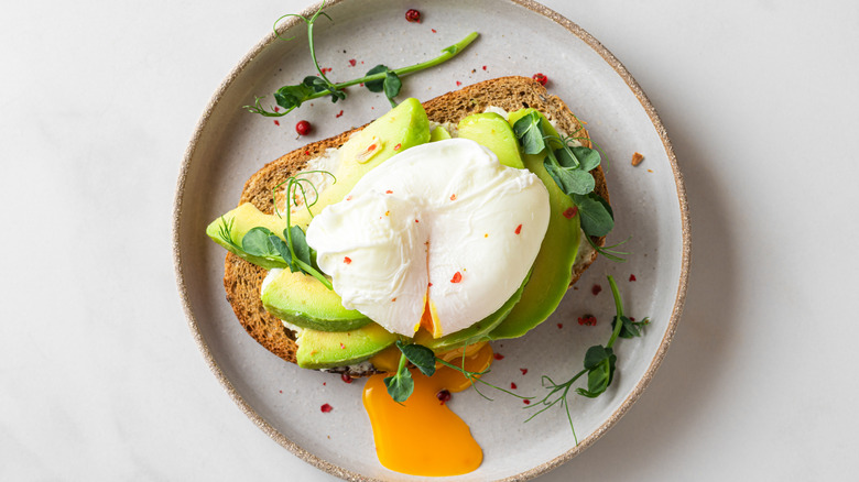 Poached egg on avocado toast white background