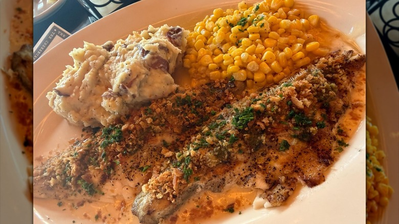 Overhead view of a plate of Cheesecake Factory's grilled branzino with mashed potatoes and corn