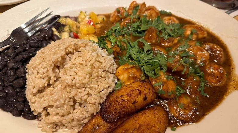 Overhead view of a plate of Cheesecake Factory's Jamaican black pepper shrimp with sides