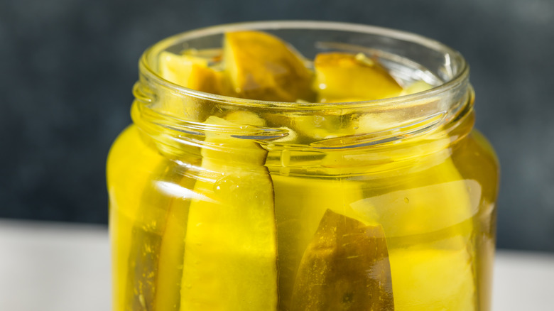 Close up of dill pickle spears inside of a mason jar