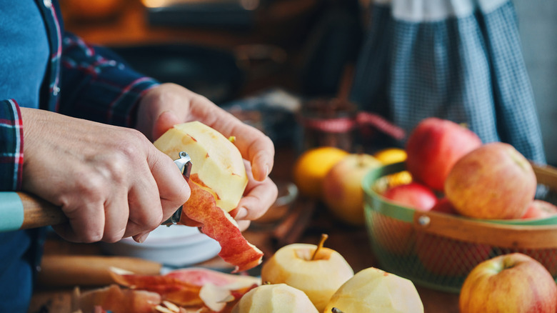 A person peels apples