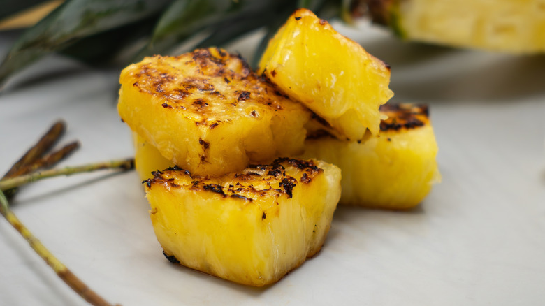 Close up of several grilled pineapple chunks piled together