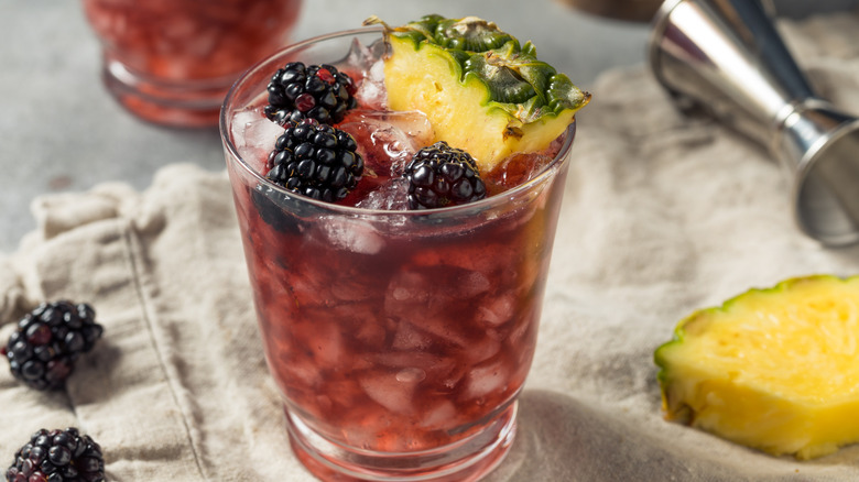 Cobbler cocktail, garnished with fresh blackberries and pineapple slices