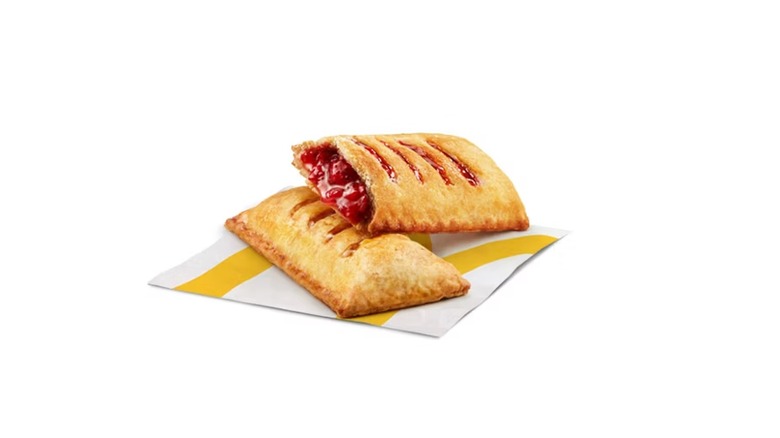 Two strawberry pies, one resting on the other against a white background
