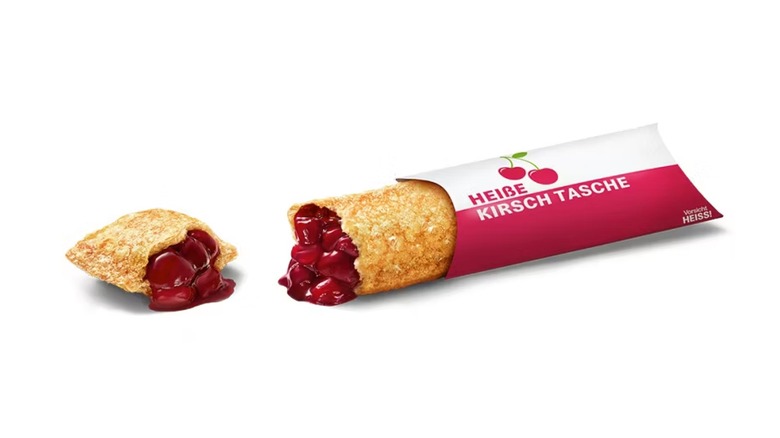 A pice cut up with cherry filling coming out against a white background