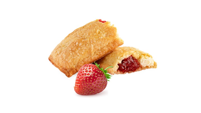 A Strawberry Custard Pie cut to show the filling with a strawberry in front against a white background