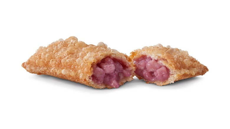 Fried pie cut in segments full of taro against a white background
