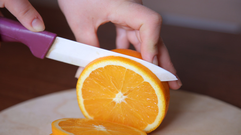 Person slicing a fresh orange