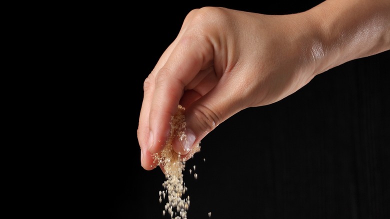 Person sprinkling brown sugar