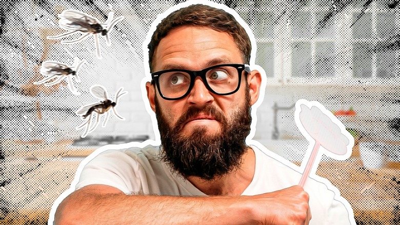 Man trying to swat away a swam of gnats