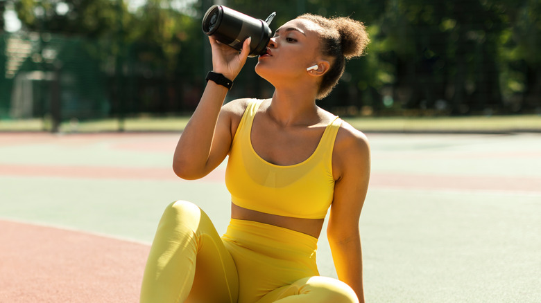 woman enjoying protein shake after workout