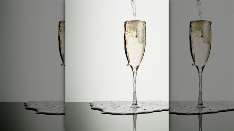Over filled sparkling wine glass