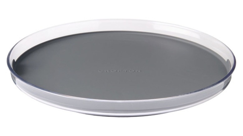 A simple black turntable with clear sides against a white backdrop.