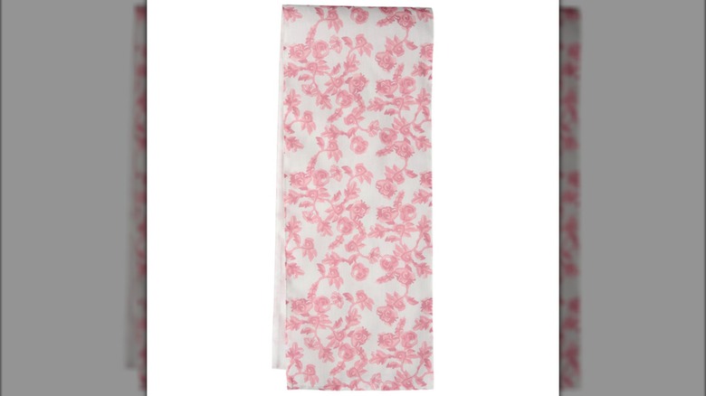A pink and white floral print table runner