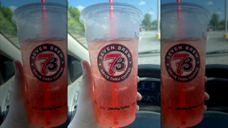 A hand holds a Cherry Limeade from 7 Brew