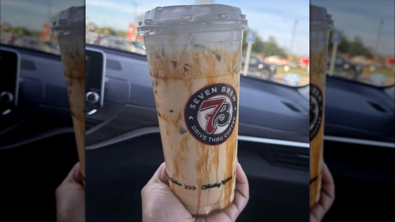 A hand holds an Iced Cookie Butter Blondie from 7 Brew