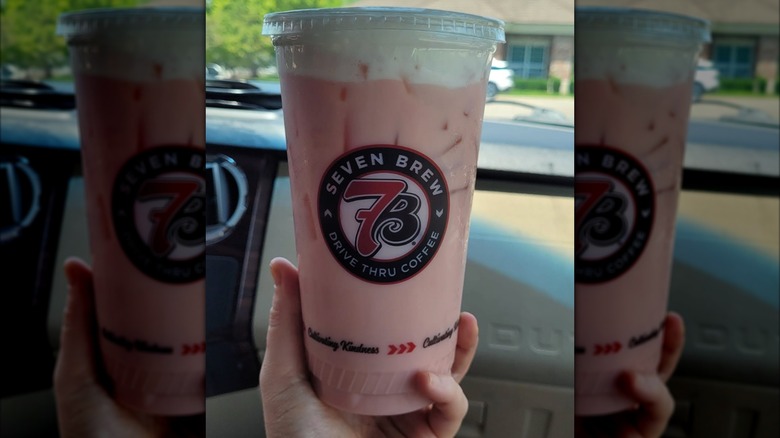 A hand holds a Strawberry Horchata Chai from 7 Brew