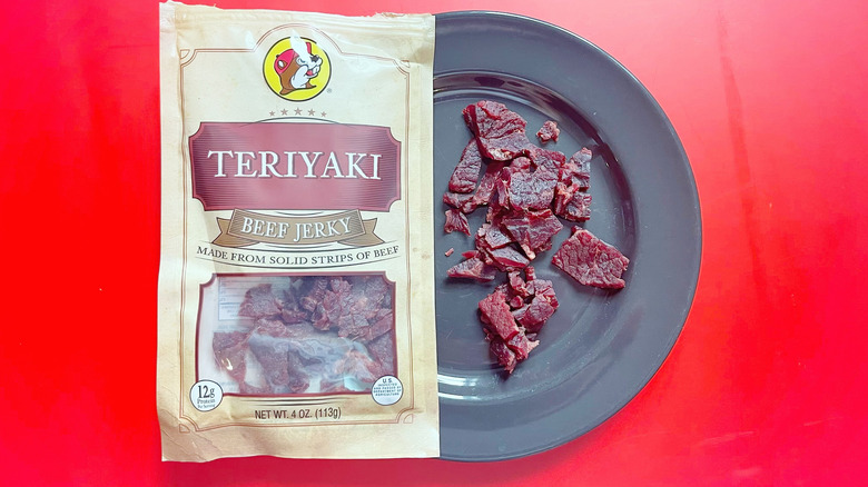 A bag of Teriyaki jerky on a plate with some jerky