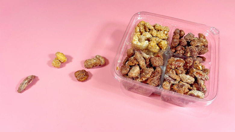 A plastic container with glazed nuts