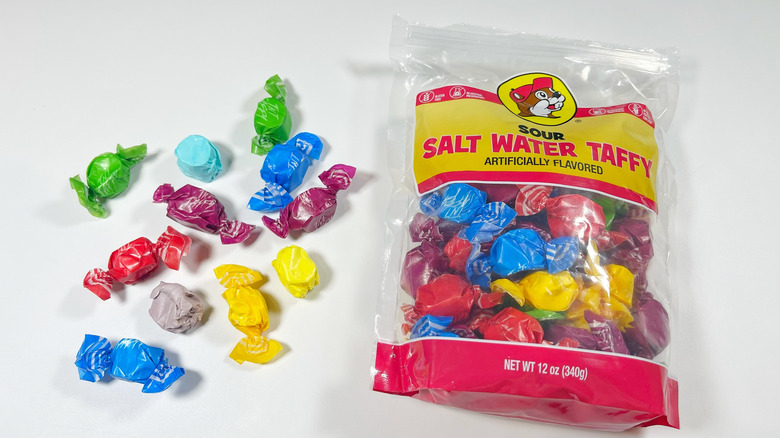 A bag of Sour Salt Water Taffy with a few out of their wrappers