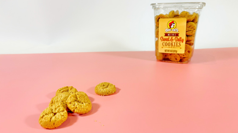 A container of Buc-ee's cookies in the background with a few cookies in the foreground
