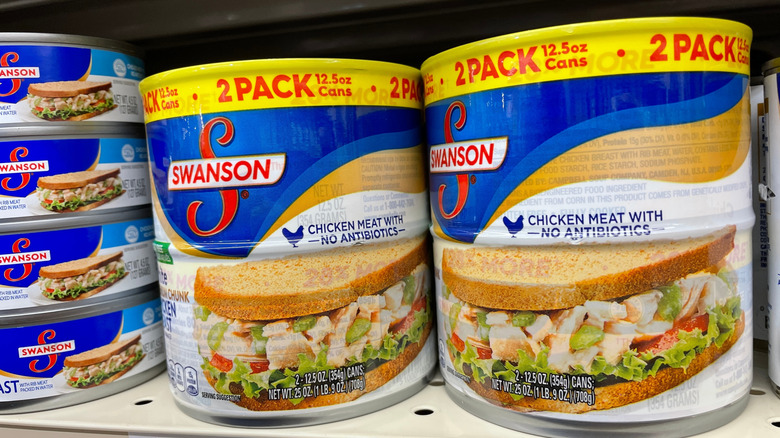 Two packs of Swanson's canned chicken breast on a store shelf