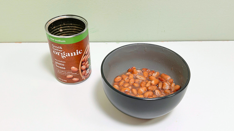 A can of Good and Gather Low Sodium Organic Pinto Beans next to a bowl of pinto beans