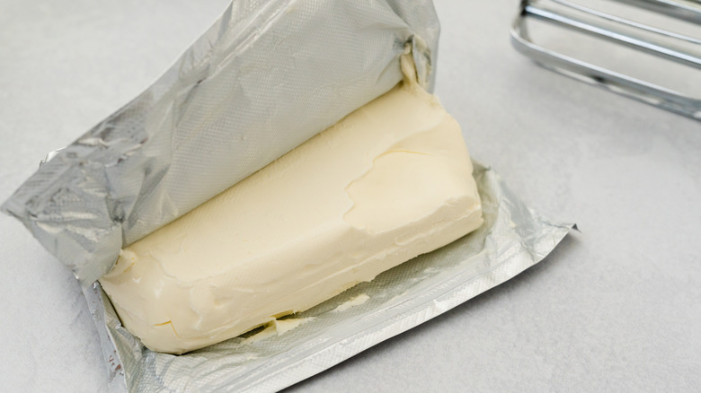 A close up of an opened block of cream cheese